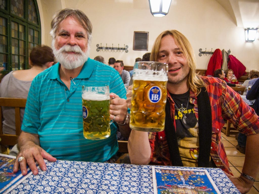 two men with steins of beer in a biergarten in Munich, Germany