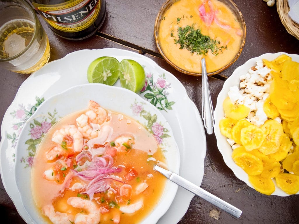 shrimp ceviche with popcorn, plantains, and a beer in Quito, Ecuador. One fun way to build your travel plan is around the food!