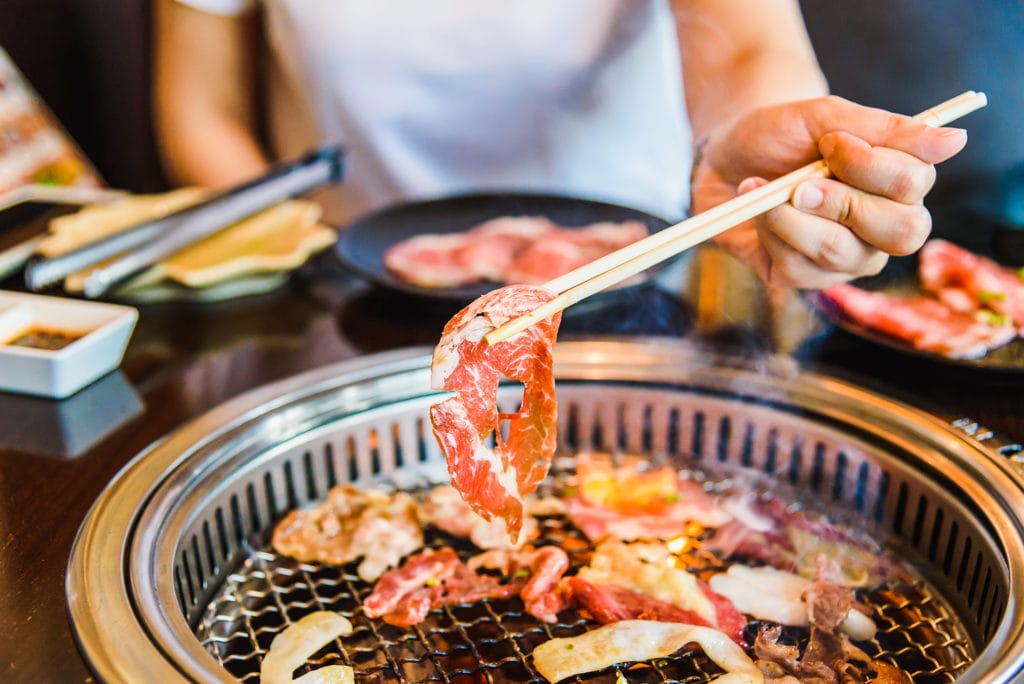 a woman grilling Yakiniku at her table